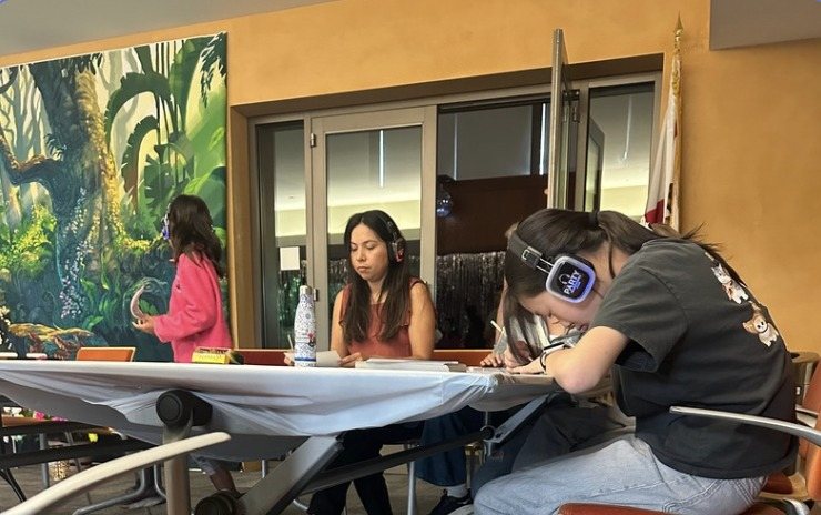 Guests drawing and coloring in front of a large jungle mural
