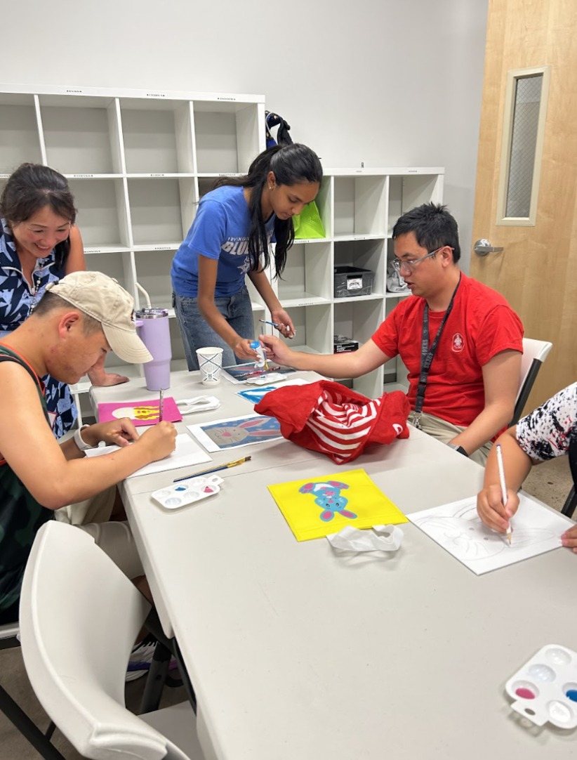 Participants and CARES officers painting bunnies at a long table