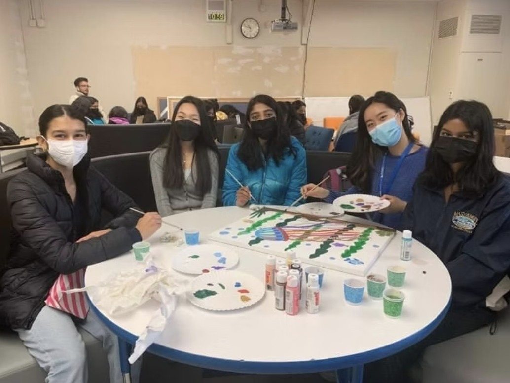 Students painting together at a round table in the wellness center