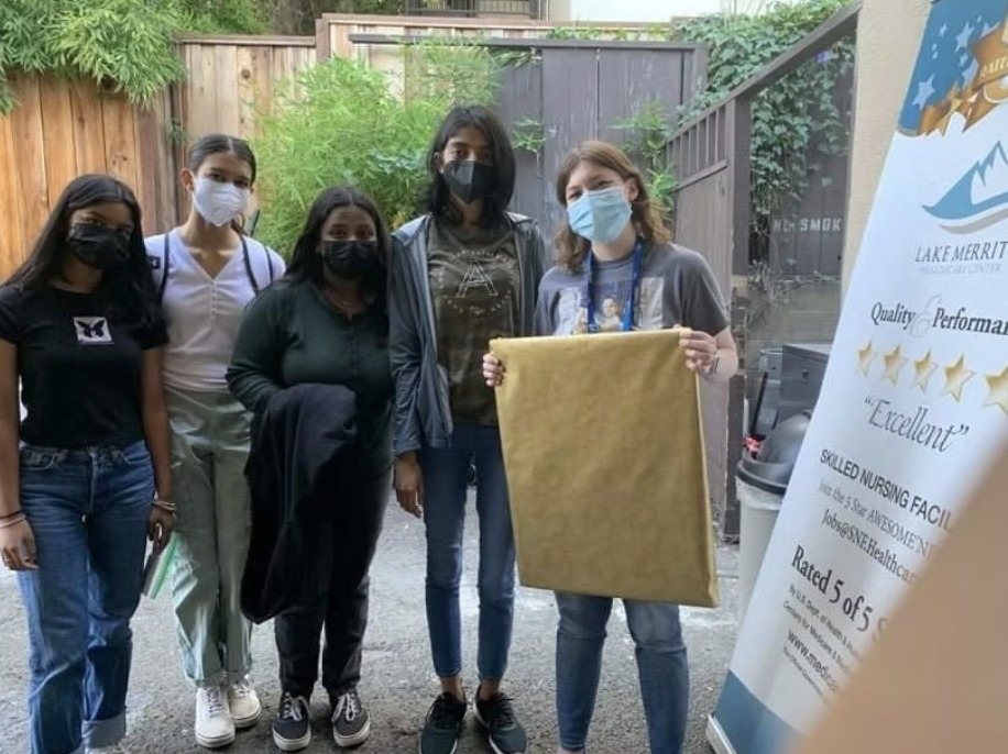 CARES officers delivering the wrapped painting outside Lake Merritt Healthcare Center