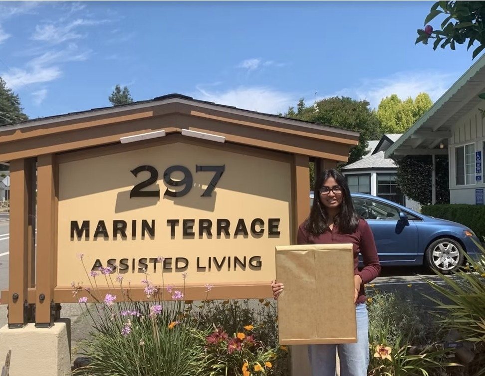 A CARES officer standing by the Marin Terrace Assisted Living sign