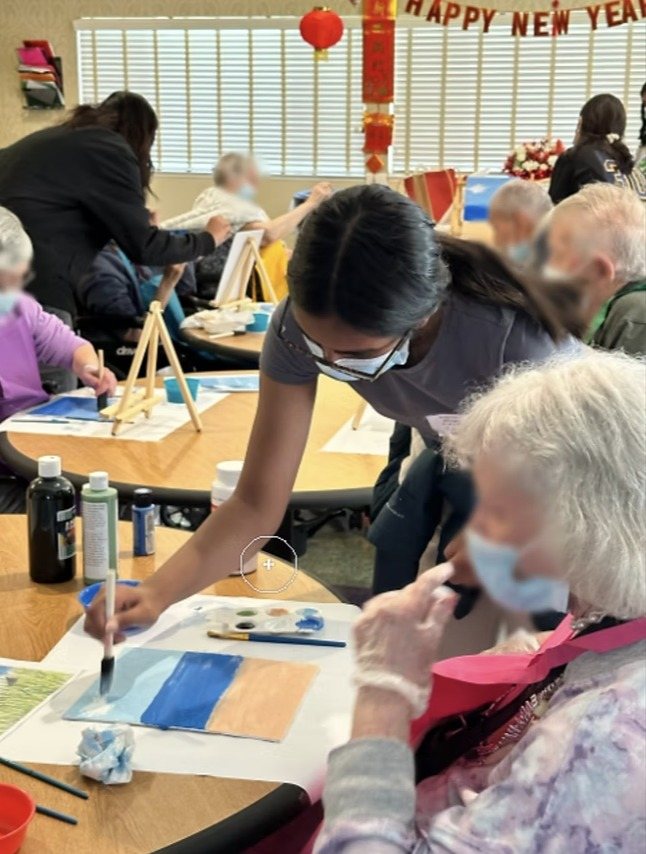 A CARES officer helping a resident paint a blue sky