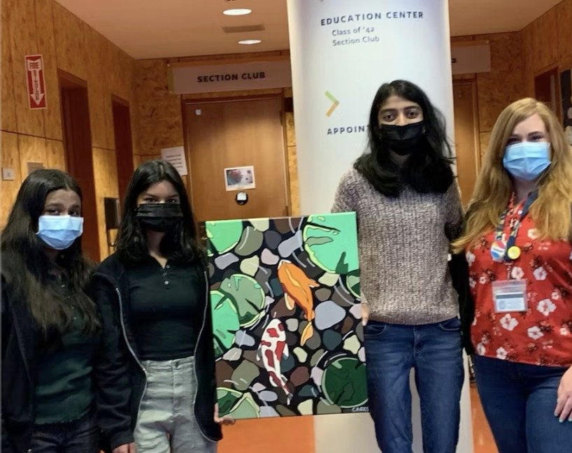 CARES officers holding the koi pond painting "Tranquility" with Tang Center staff