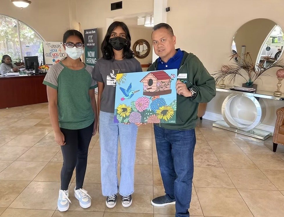 CARES officers delivering the painting to a Valley Health Rehabilitation Center staff member