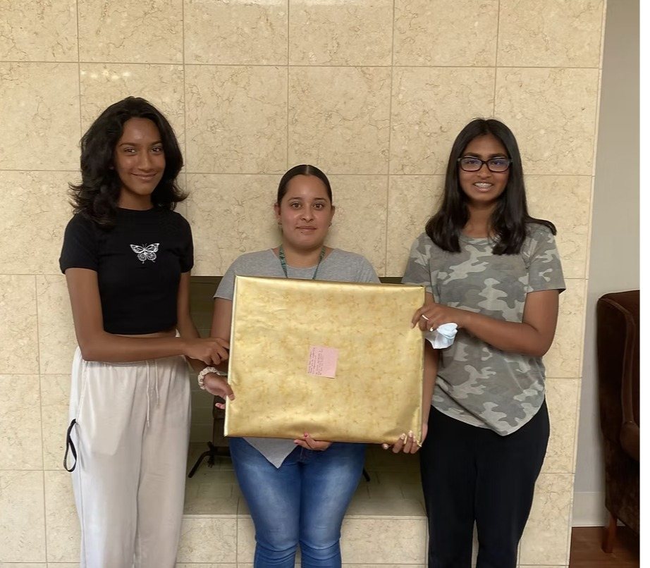 CARES officers handing over the wrapped painting at Windsor Post Acute Care Center